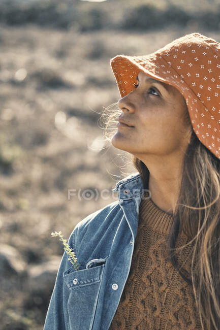 Retrato de una hermosa joven con sombrero y gorra de paja en la playa - foto de stock