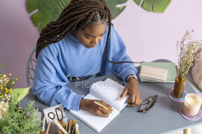 Jovem escrevendo e trabalhando em seu escritório — Fotografia de Stock