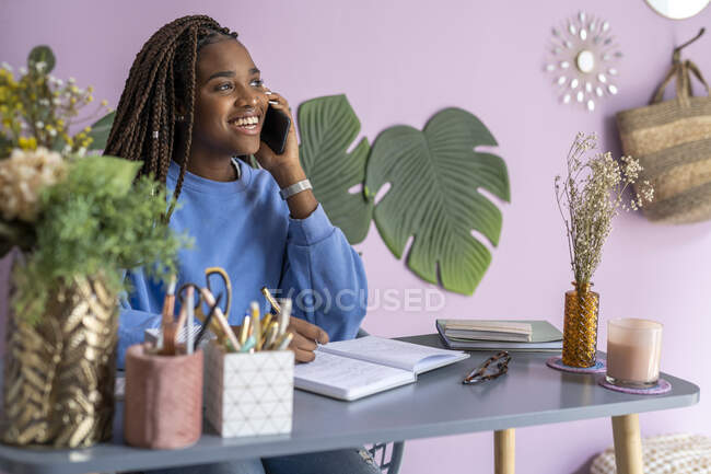 Молода бізнес-леді розмовляє і працює вдома — стокове фото