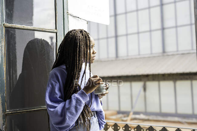 Дівчина думає і п'є каву на балконі — стокове фото