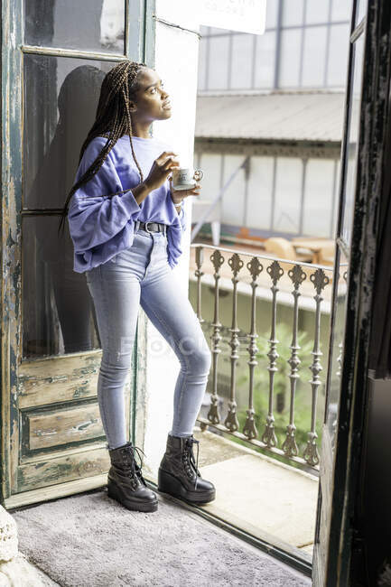 Menina beber café na varanda de sua casa — Fotografia de Stock