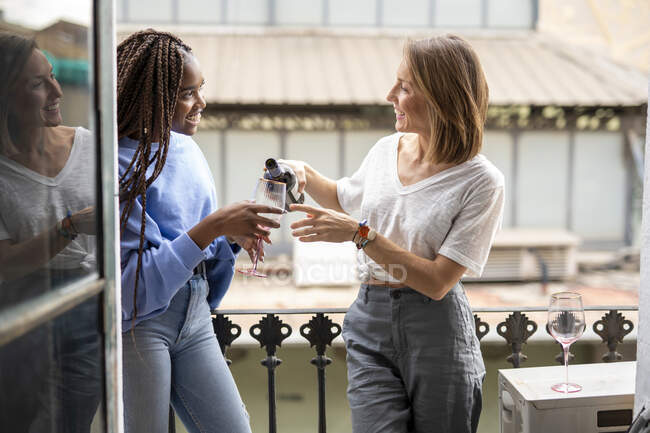 Couple of friends drinking wine on the balcony — Stock Photo