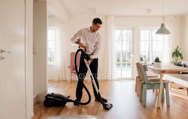 Homme d'affaires nettoyer sa maison avant de travailler de la maison — Photo de stock
