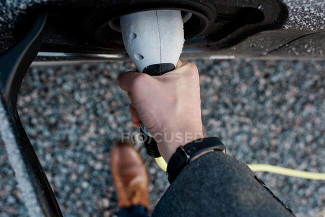 Mans mano tenendo spina auto elettrica — Foto stock