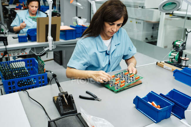Varios empleados que trabajan en una fábrica en su mesa - foto de stock