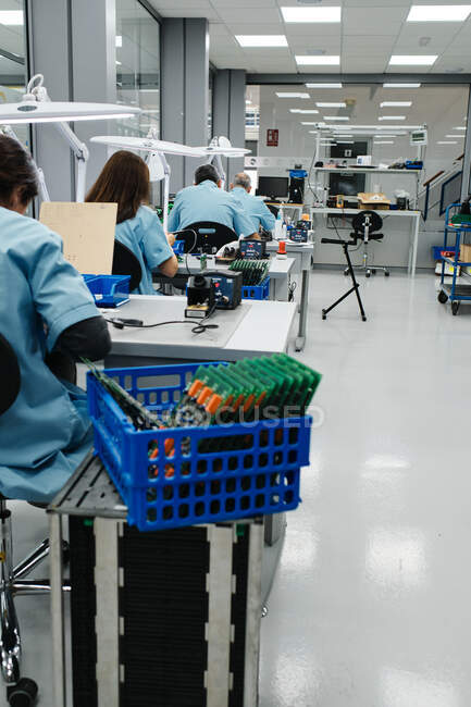 Varios trabajadores fabrican los productos en su mesa de trabajo - foto de stock