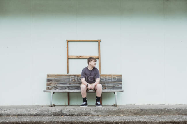 Teenager sitzt allein auf einer Holzbank — Stockfoto