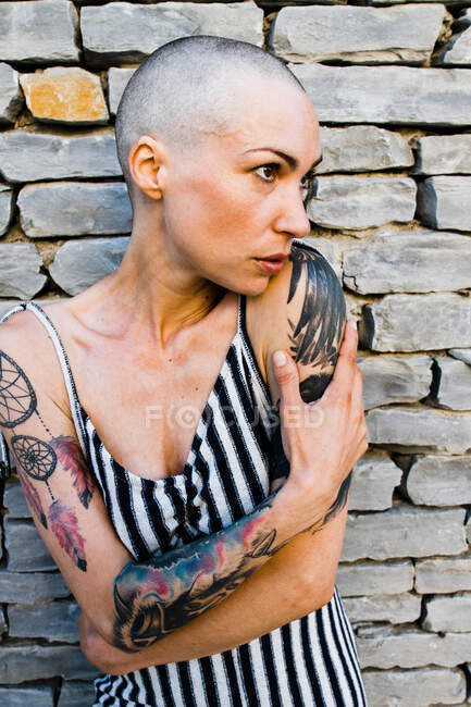 Young woman with shaved head looking to the side — Stock Photo