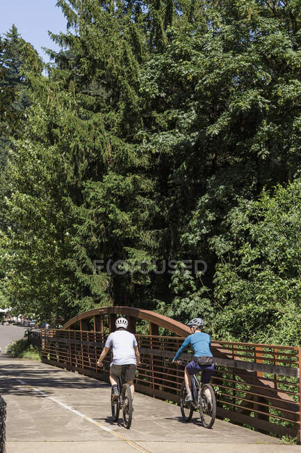 Um jovem casal andar de bicicleta em um trilho perto de Troutdale, Oregon. — Fotografia de Stock