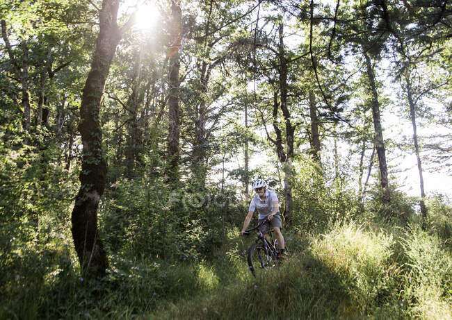 Ein junger Mann fährt mit seinem Mountainbike auf einem Trail in Oregon. — Stockfoto