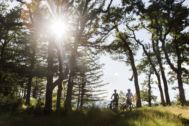 A young couple ride bikes on a trail near Cascade Locks, Oregon. — Stock Photo