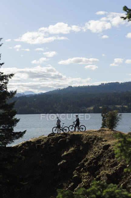 Una joven pareja disfruta de una vista del río Columbia mientras pedalea en O. - foto de stock