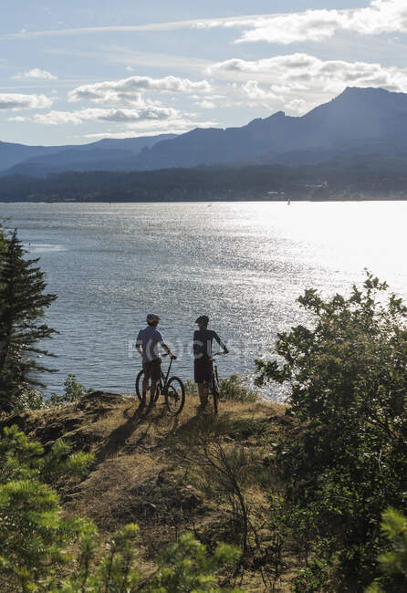 Молода пара насолоджується видом на річку Колумбія під час їзди на велосипеді в АБО.. — стокове фото