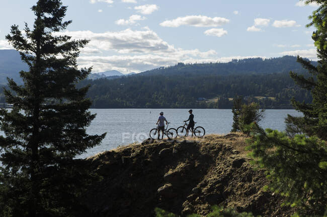 Una joven pareja disfruta de una vista del río Columbia mientras pedalea en O. - foto de stock