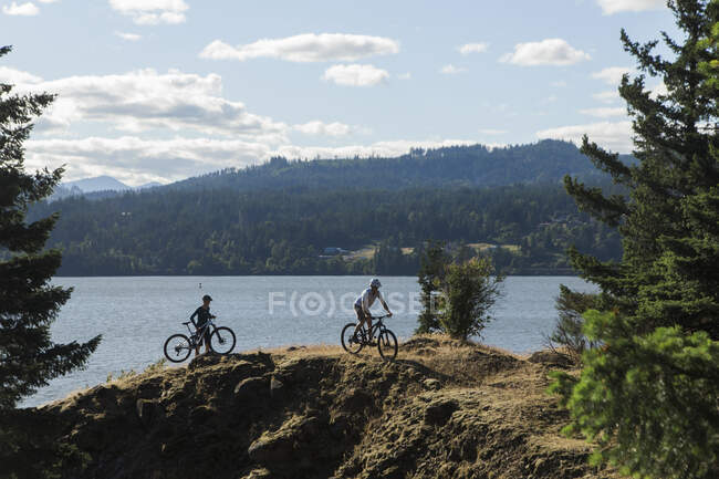 Um casal desfruta de uma vista do rio Columbai enquanto pedala em Oregon. — Fotografia de Stock