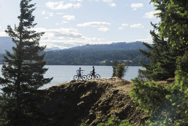 A young couple enjoy a view of the Columbia River while biking in OR. — Stock Photo