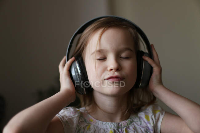 A menina ouve música com fones de ouvido . — Fotografia de Stock