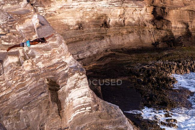 Чорний, чоловічий скелястий дайвер стрибає зі скелі в оаху Гаваї в океан — стокове фото