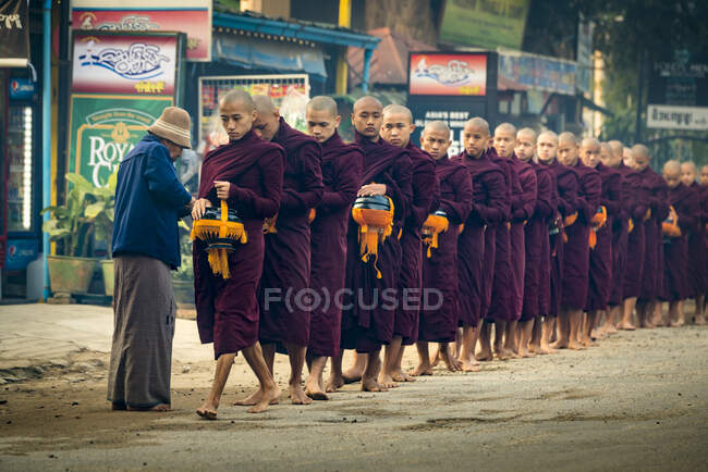 Moines dans la rue alignés et recevant l'aumône, Nyaung U, Bagan, Myanmar — Photo de stock