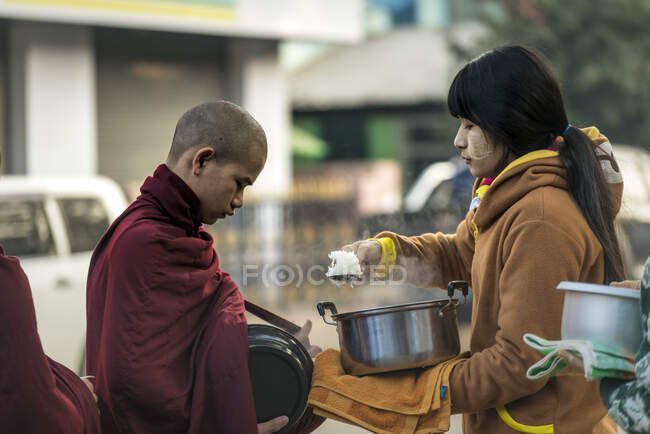 Burmese woman giving spoon of steamed rice to monk, Nyaung U, Bagan, Myanmar — Stock Photo