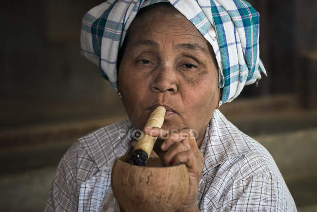 Birmano mujer fumando grueso Birmano paja cigarro, Bagan, Myanmar - foto de stock