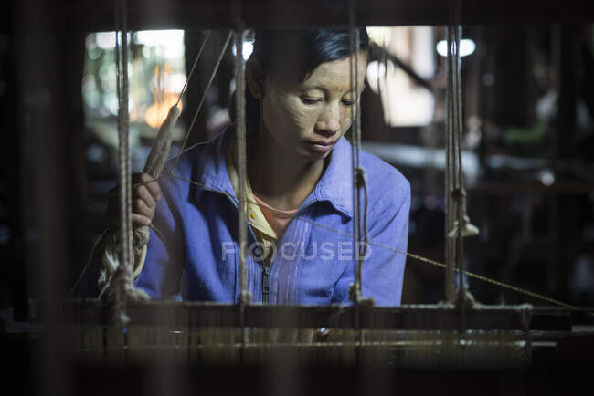Азиатка, работающая в ткацком производстве — стоковое фото