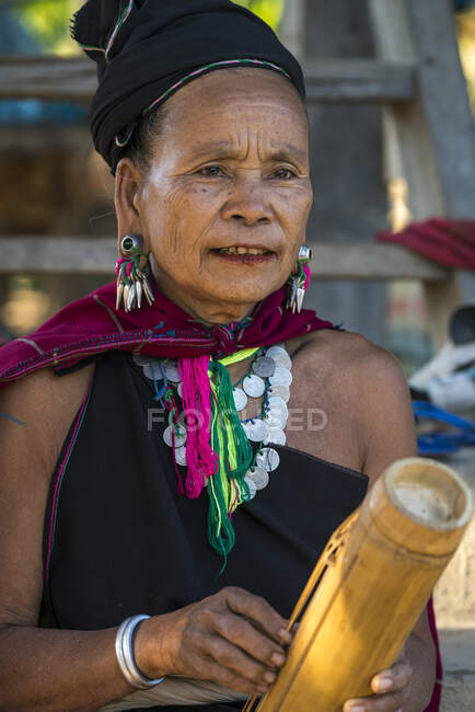 Donna adulta della tribù Kayah che suona uno strumento musicale di bambù, vicino a Loikaw, Myanmar — Foto stock