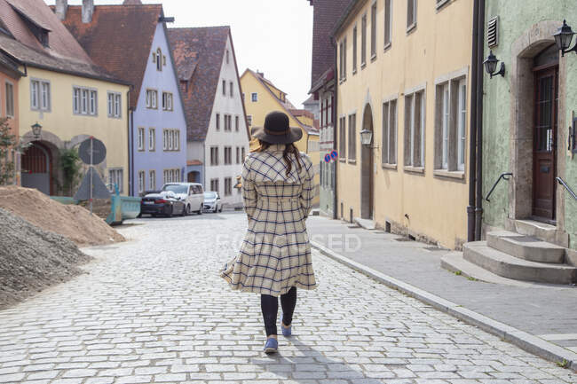 Жінка в довгому плащі блукає вулицями Німеччини. — стокове фото