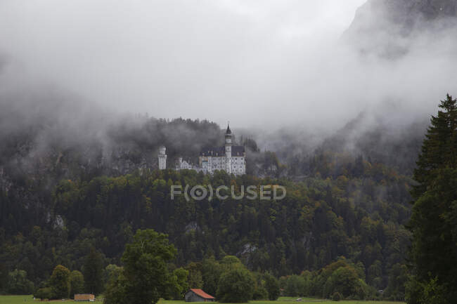 Castello Neuschwanstein visto attraverso la nebbia in Baviera, Germania — Foto stock