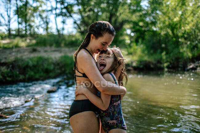 Two girls hugging and laughing on a warm summer day — Stock Photo