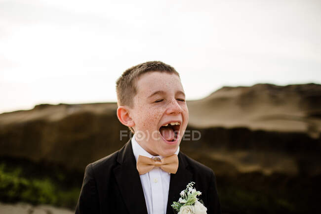 Garçon de neuf ans à Tux debout sur la plage à San Diego — Photo de stock