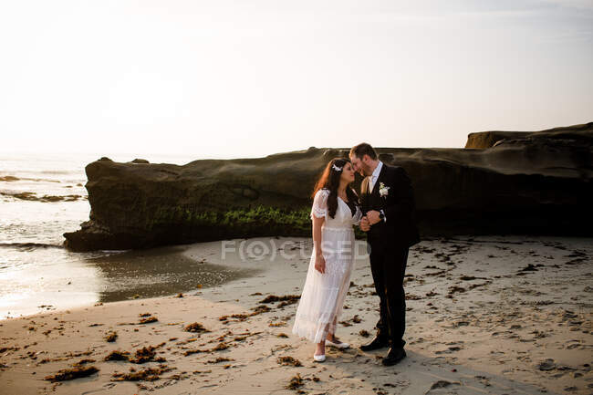 Recém-casados na praia ao pôr do sol em San Diego — Fotografia de Stock