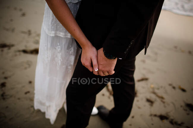 Gros plan des jeunes mariés mains sur la plage à San Diego — Photo de stock