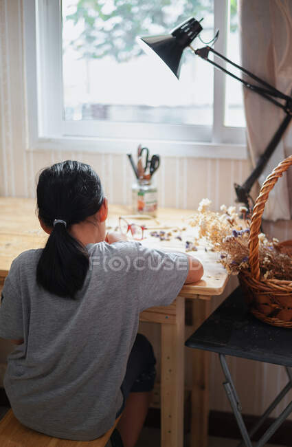 Uma menina fazendo um livro feito à mão sozinha — Fotografia de Stock