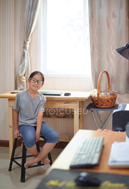 Портрет девушки, сидящей перед рабочим столом — стоковое фото