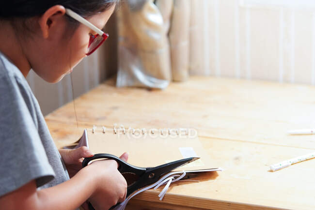 Ein Mädchen schneidet das Bastelbuch — Stockfoto