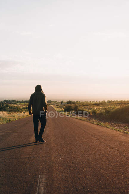 Young man walking on street at sunrise — Stock Photo