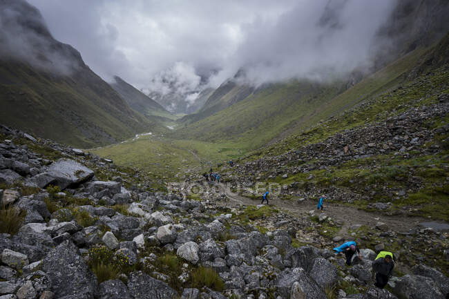 Hikers ascending through valley on Salkantay trail towards Salkantay Pass in foggy weather, Peru — Stock Photo