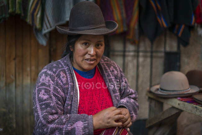 Mulher que vende chapéus e roupas no mercado em Pisac (Pisaq), Sacred Valley, Cusco, Peru — Fotografia de Stock