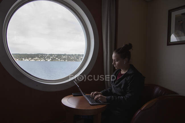 Вид профілю молодої жінки, що працює на ноутбуці у човні — стокове фото