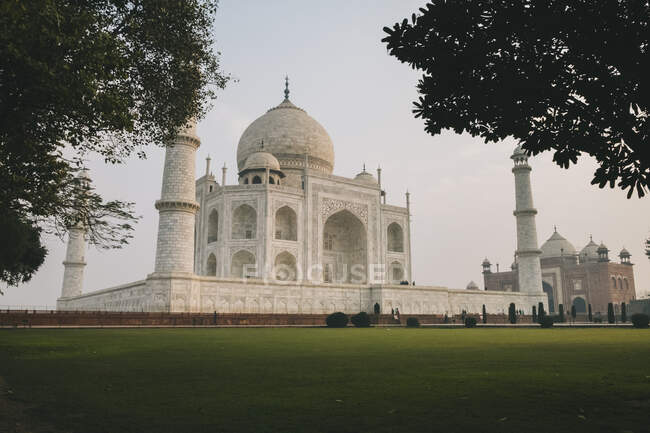 Taj Mahal surrounded by trees in the symmetrical gardens around the complex  during sunrise, Agra, India — North India, history - Stock Photo |  #432571228