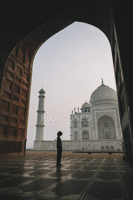 Jovem mulher olhando para Taj Mahal de dentro Kau Ban Mesquita durante o nascer do sol, Agra, Índia — Fotografia de Stock
