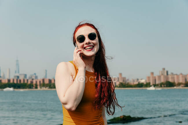 Jovem mulher falando ao telefone à beira-mar — Fotografia de Stock