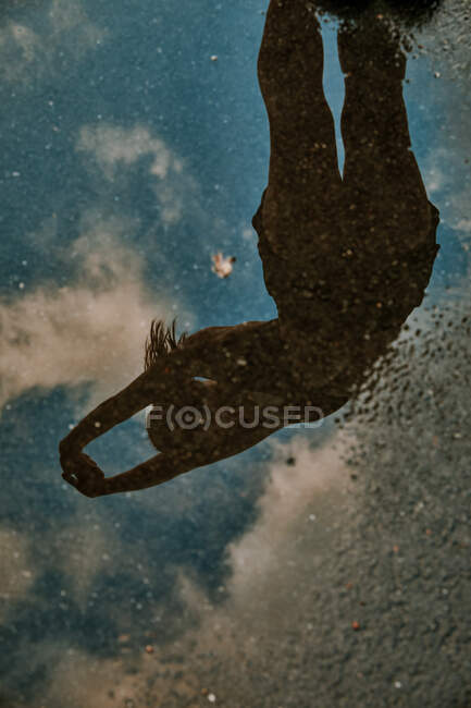 Отражение в воде растяжения женщины-спортсмена. — стоковое фото
