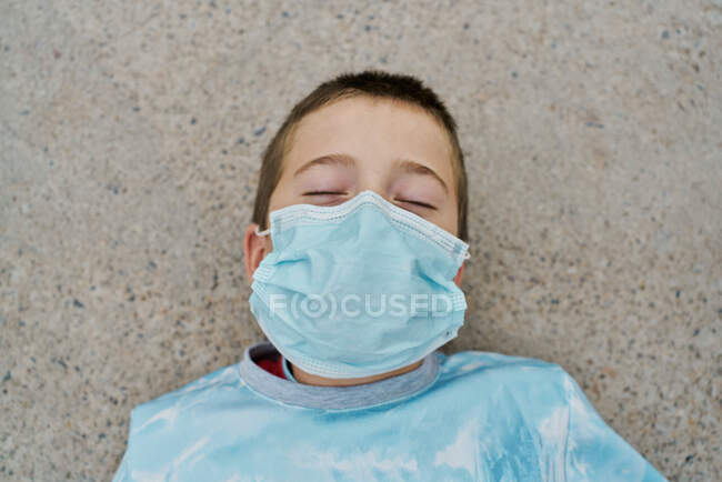 Detalhe do menino com máscara está deitado no chão e rindo com — Fotografia de Stock