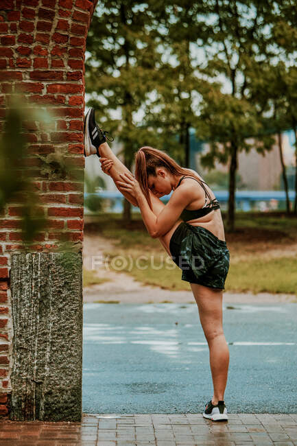 Mujer joven haciendo ejercicio al aire libre en el parque - foto de stock