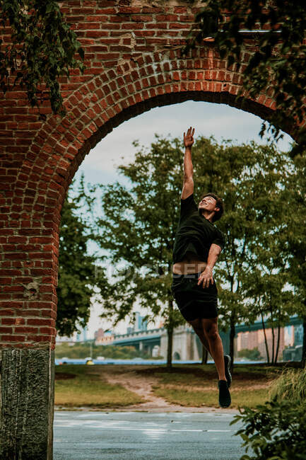 Молодий чоловік стрибає високо на відкритому повітрі в парку — стокове фото