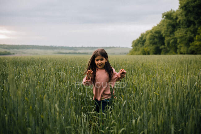 Niño riendo corriendo por el campo al atardecer - foto de stock