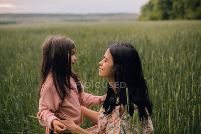Sorrindo mãe e filha e conversando no campo — Fotografia de Stock