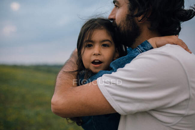 Dad kissing daughter while carrying her on hike — Stock Photo